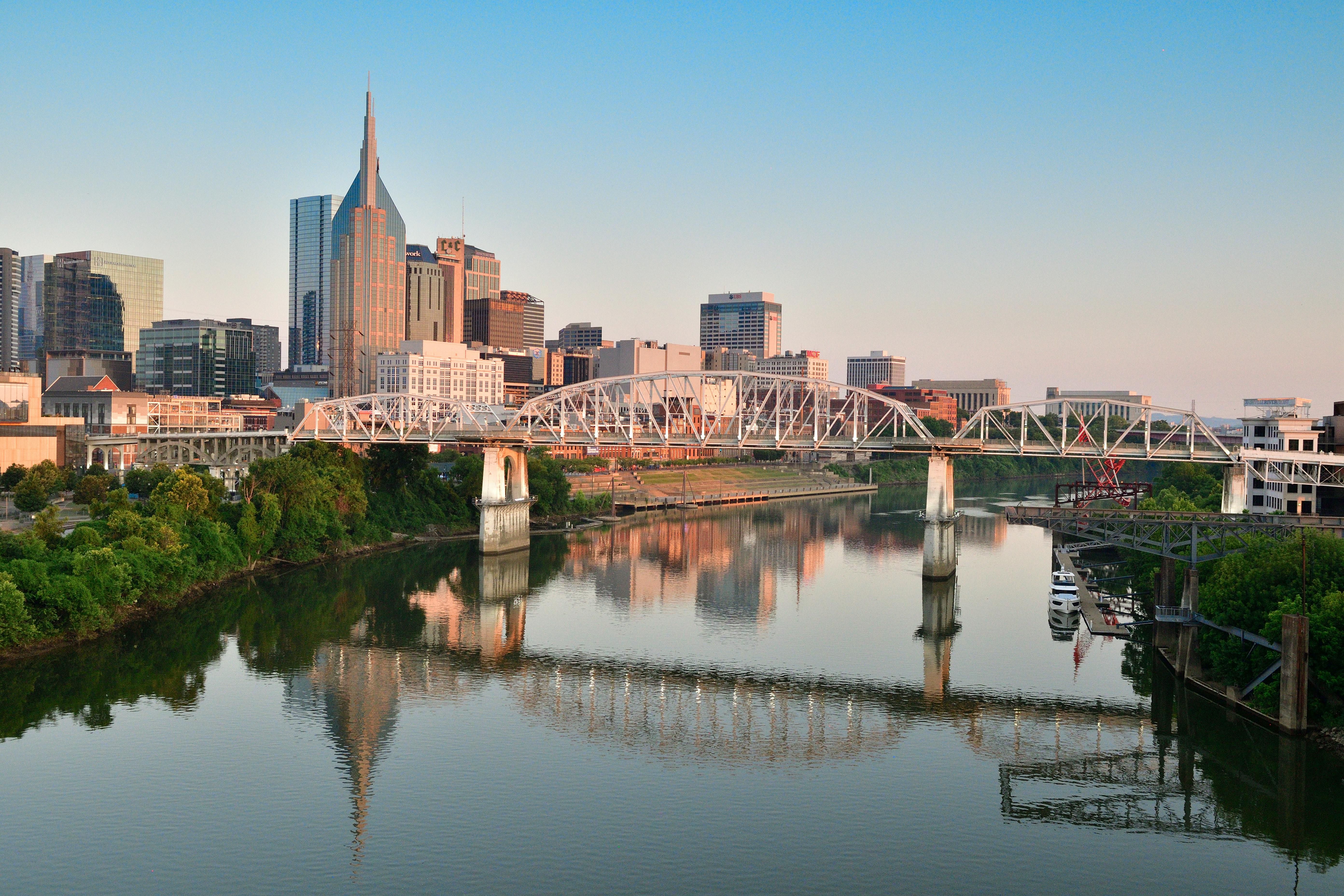 Sky-line view of downtown Nashville from the East side. You see the city, bridge, and river.